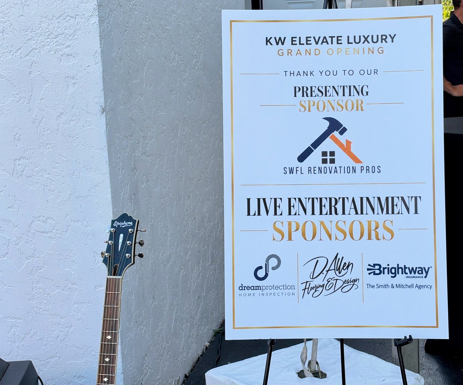 KW Elevate Luxury Grand Opening in Naples, FL - Live Entertainment Sponsors sign next to James Grande's guitar