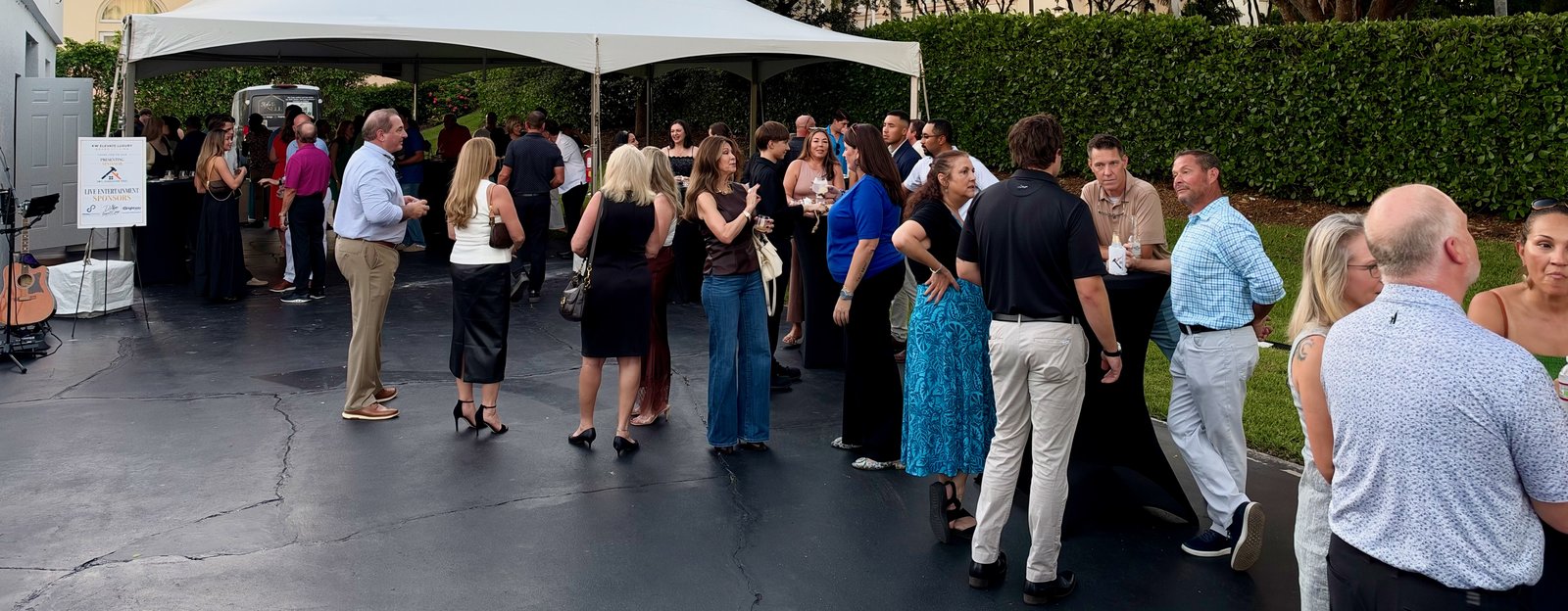 Guests networking at a corporate grand opening in Naples, FL with live acoustic music by James Grande